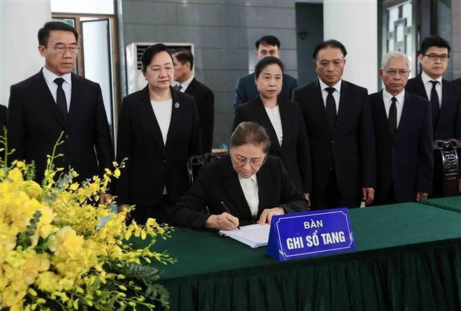 La vicepresidenta de Laos, Pany Yathotou, escribe en el libro de condolencias del expresidente Tran Duc Luong. (Foto: VNA)