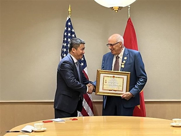 El vicepresidente y secretario general de la Unión de Organizaciones de Amistad de Vietnam, Phan Anh Son, entrega el sello conmemorativo “Por la paz y la amistad entre los pueblos” a Ron Carver, activista social estadounidense por la paz. (Fotografía: VNA)