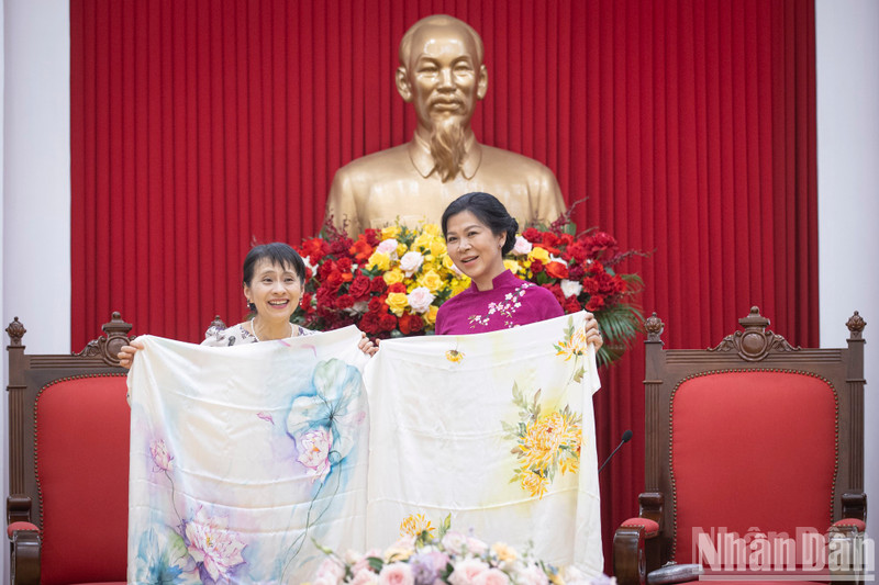 Ngo Phuong Ly, esposa del secretario general del Partido Comunista de Vietnam, To Lam, entrega a la del primer ministro japonés, Ishiba Yoshiko, un pañuelo de seda estampado con flores de loto y crisantemo. (Foto: Nhan Dan)