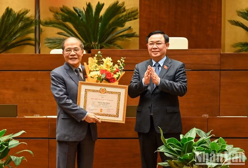 Dinh Hue confiere la insignia por 45 años de membresía del Partido Comunista de Vietnam (PCV) al expresidente de Parlamento Nguyen Sinh Hung.