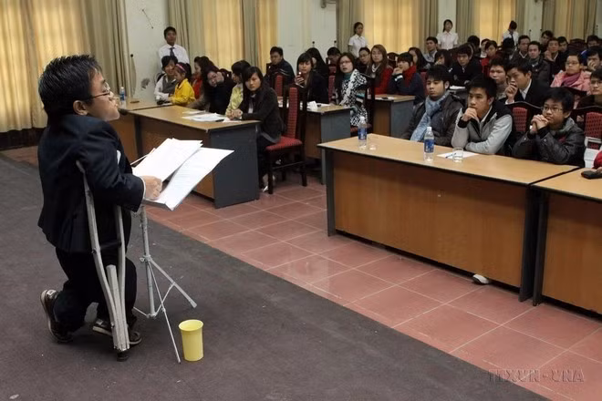 Nguyen Son Lam (nacido en 1982 en la provincia de Quang Ninh) mide sólo 90 centímetros y pesa 27 kilogramos, con ambos pies atrofiados por el Agente Naranja que recibió su padre, completó dos grados universitarios en idioma inglés y japonés, domina la comunicación en francés y participa activamente en actividades sociales. (Foto: VNA)