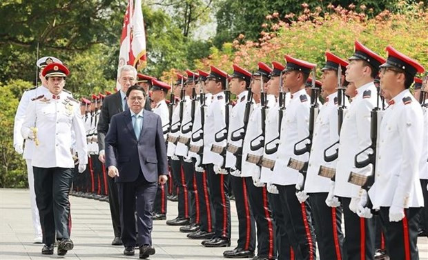 El primer ministro vietnamita, Pham Minh Chinh, y su homólogo singapurense, Lee Hsien Loong, en la ceremonia de recepción oficial (Fotografía: VNA)
