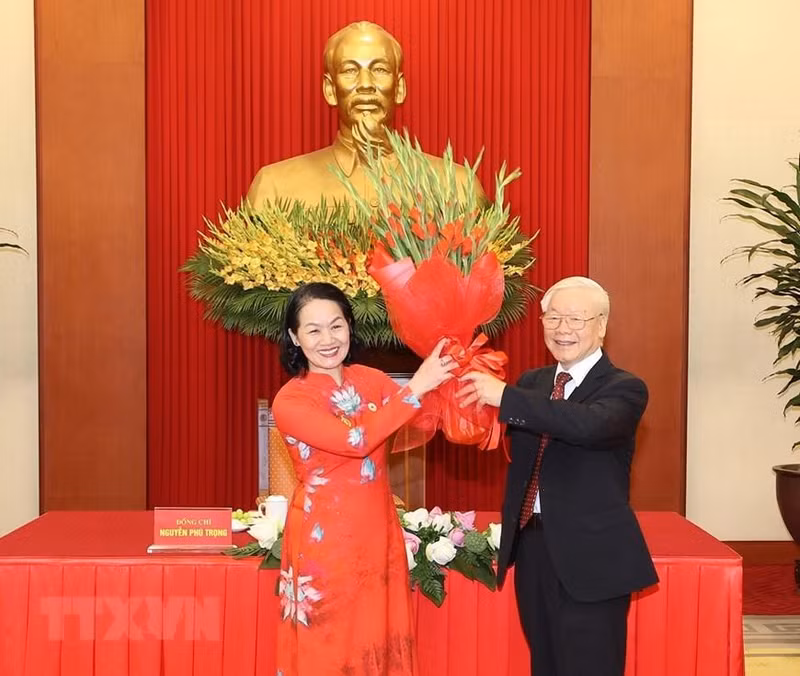 La presidenta de la Cruz Roja de Vietnam, Bui Thi Hoa entrega flores al secretario general del PCV, Nguyen Phu Trong.