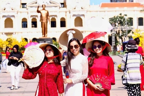 Vietnamitas que regresan del exterior exploran la calle de flores de Nguyen Hue. (Foto: qdnd.vn)