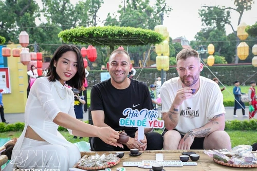 Turistas extranjeros disfrutan del té de loto del Lago Oeste. (Foto: VNA)