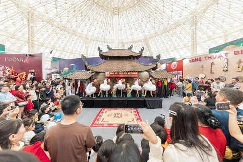 Los visitantes disfrutan de espectáculos artísticos en el espacio “Quintaesencia cultural de Vietnam”. (Foto: hanoimoi.com.vn)