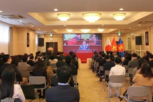 Vietnamitas residentes en Tokio siguen la inauguración del XIV Congreso Nacional del Partido.