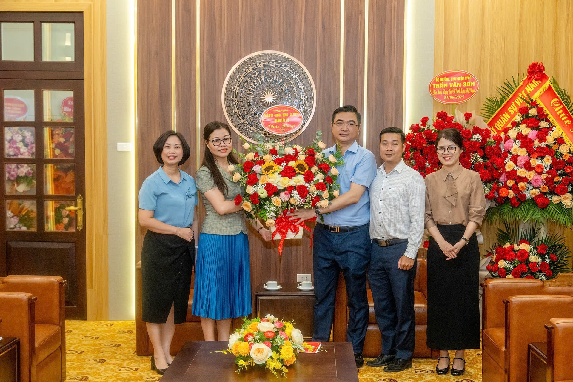 Representantes del Comité del Partido en el distrito de Tay Ho, el Consejo Popular y el Comité Popular de esa localidad entregan flores de felicitación al periódico Nhan Dan.