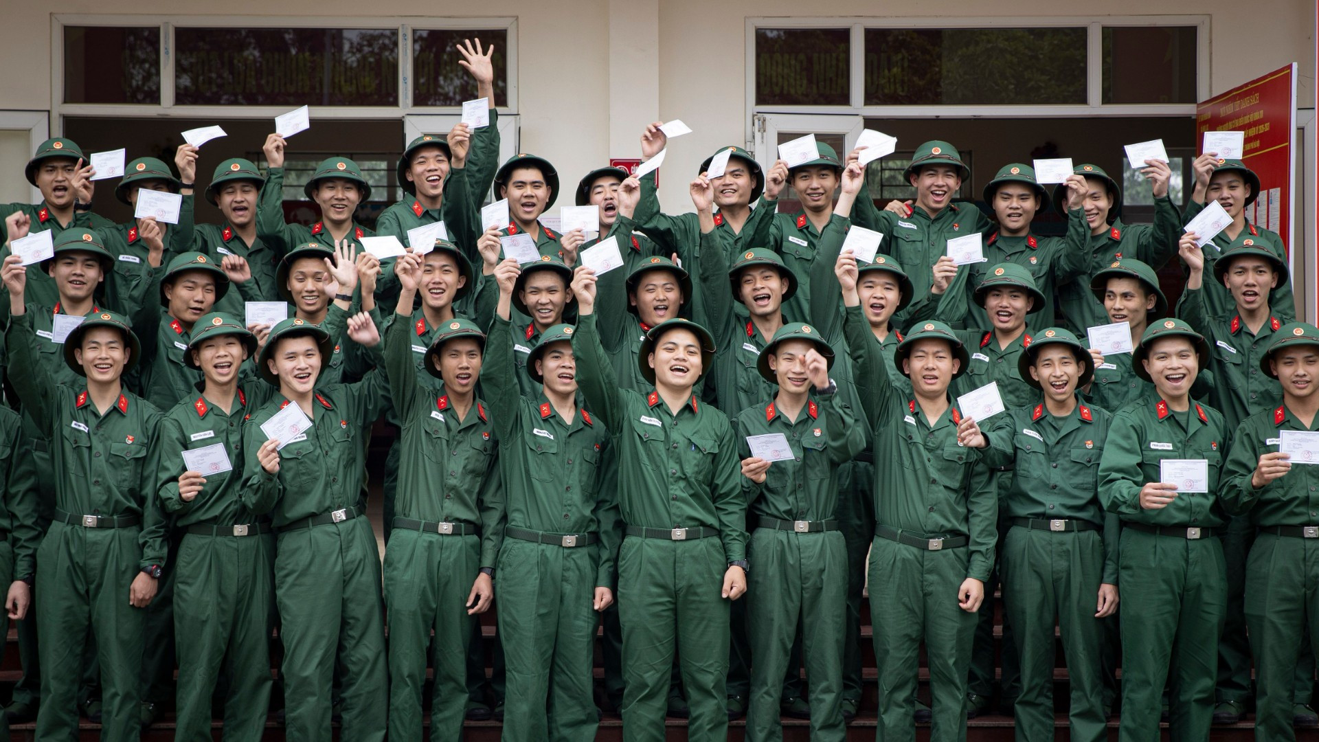 Los nuevos reclutas del Pelotón 14 de la Compañía 15 (Batallón 4, Brigada 144, Estado Mayor General del Ejército Popular de Vietnam), regocijados al sostener sus papeletas de votación para las próximas elecciones generales.