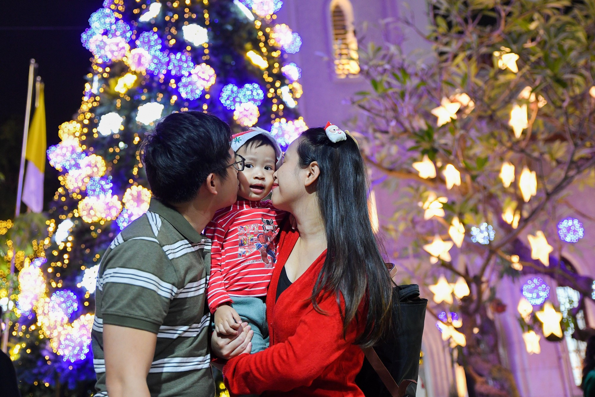 Una familia lleva a su niño a la iglesia de Ham Long para la misa de Nochebuena.