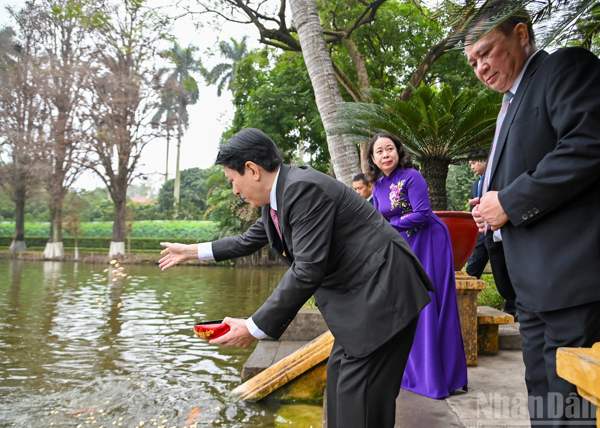 Los delegados dan de comer a peces en el Estanque del Tío Ho, otra reliquia del recinto.