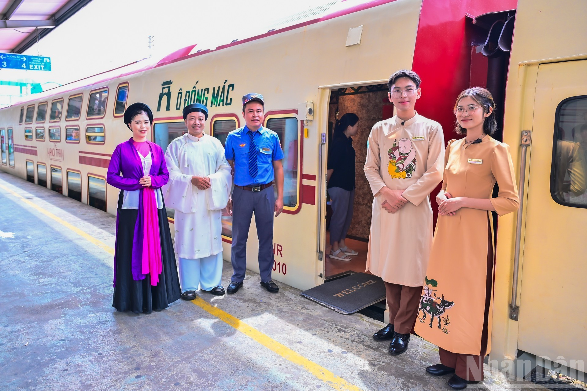 En la estación de Hanói, empleados, tripulantes y artistas esperan a los pasajeros.