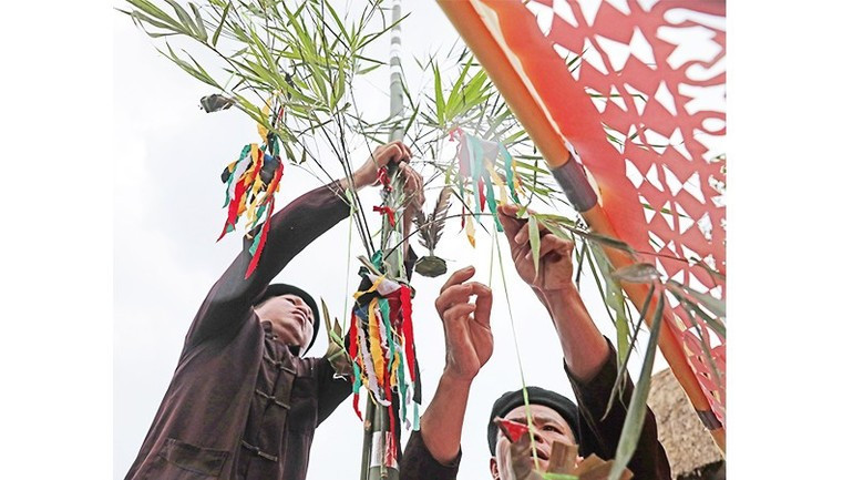 Colgar objetos en el árbol Neu (un símbolo espiritual del Año Nuevo Lunar vietnamita) implica deseos de un año de abundante cosecha.
