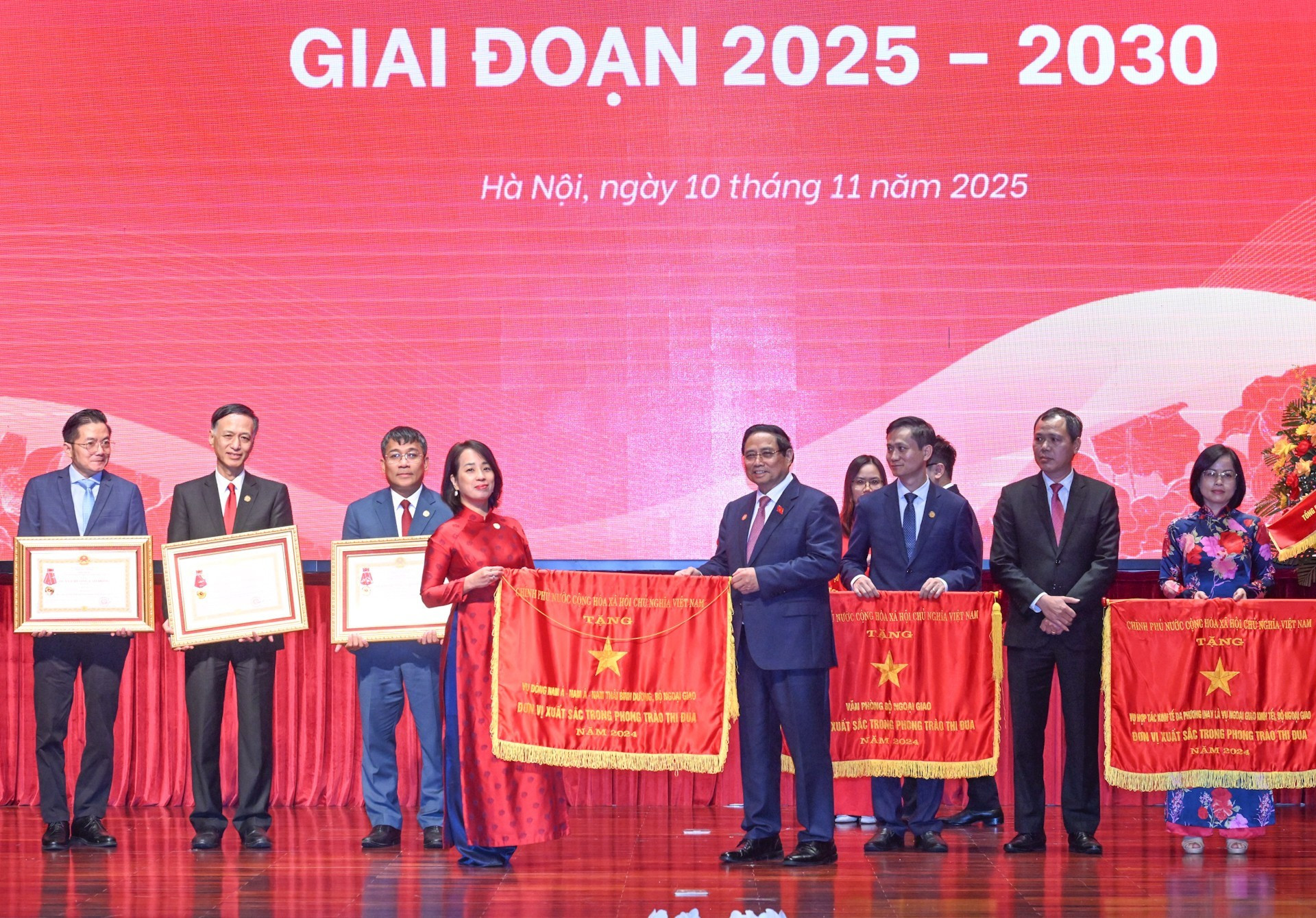 El primer ministro Pham Minh Chinh entrega el gallardete de emulación del Gobierno al Departamento de Información y Prensa de la cancillería.