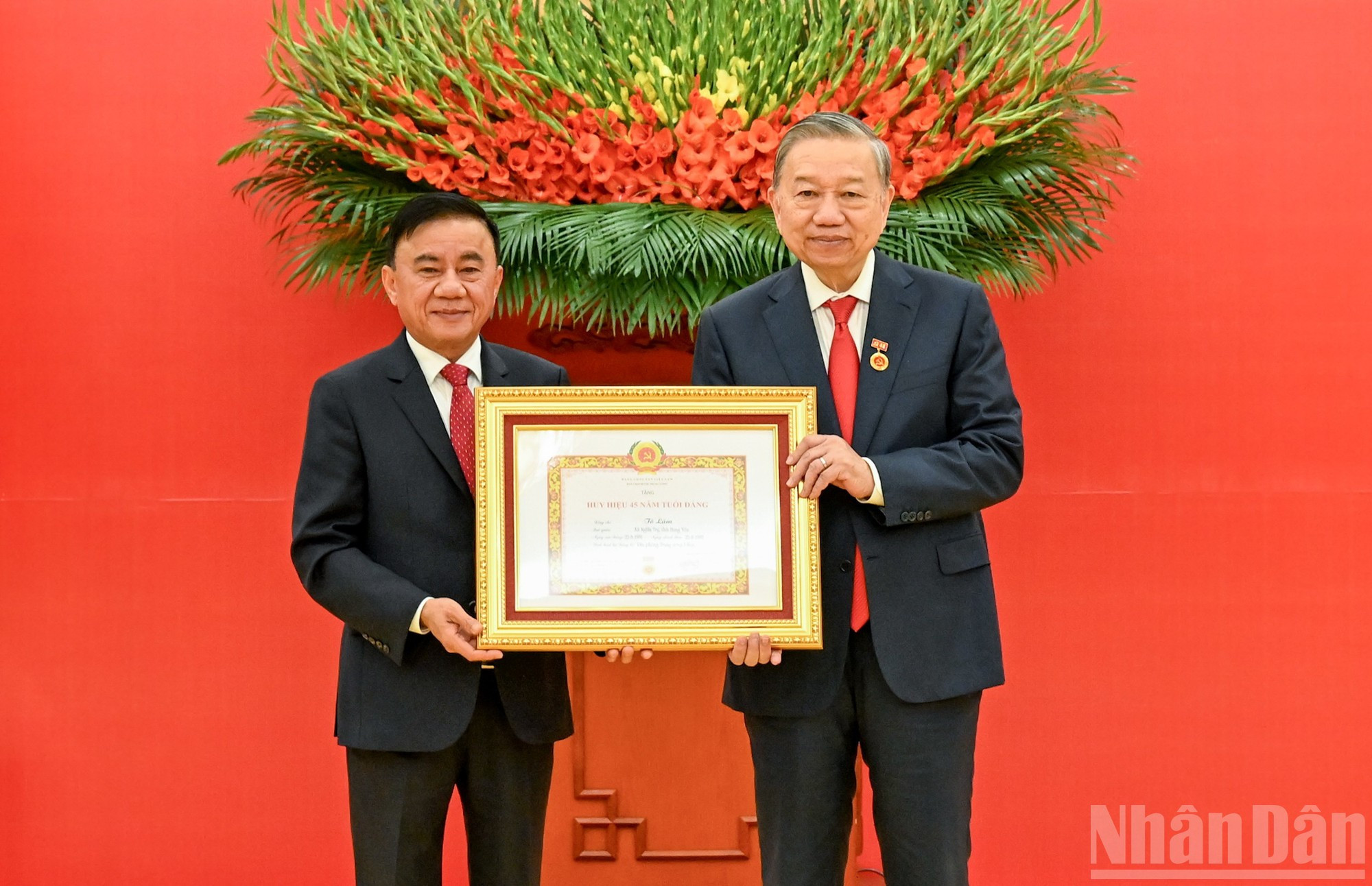 El integrante del Buró Político y miembro permanente del Secretariado del Comité Central del Partido, Tran Cam Tu, entrega al secretario general del Partido, To Lam, el certificado de reconocimiento al respecto.