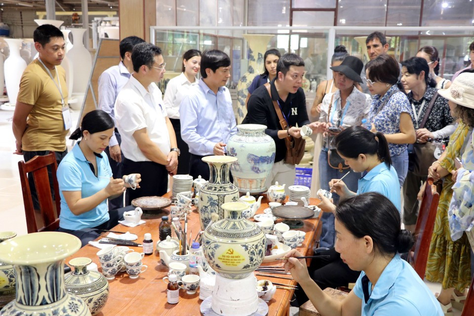 Los visitantes muestran interés en el proceso artesanal de la cerámica de Chu Dau. Los visitantes muestran interés en el proceso artesanal de la cerámica de Chu Dau.