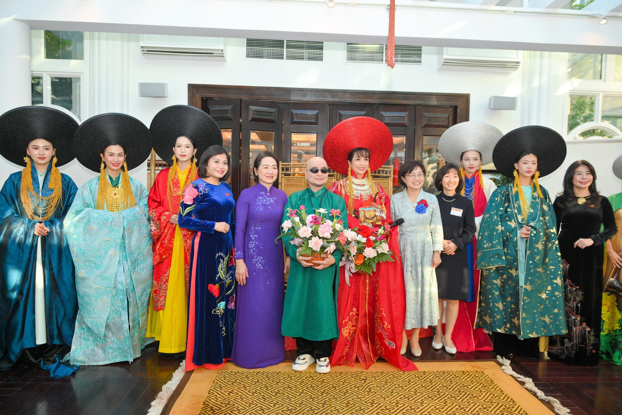 Las dos damas posan junto con los artistas participantes en la actividad.