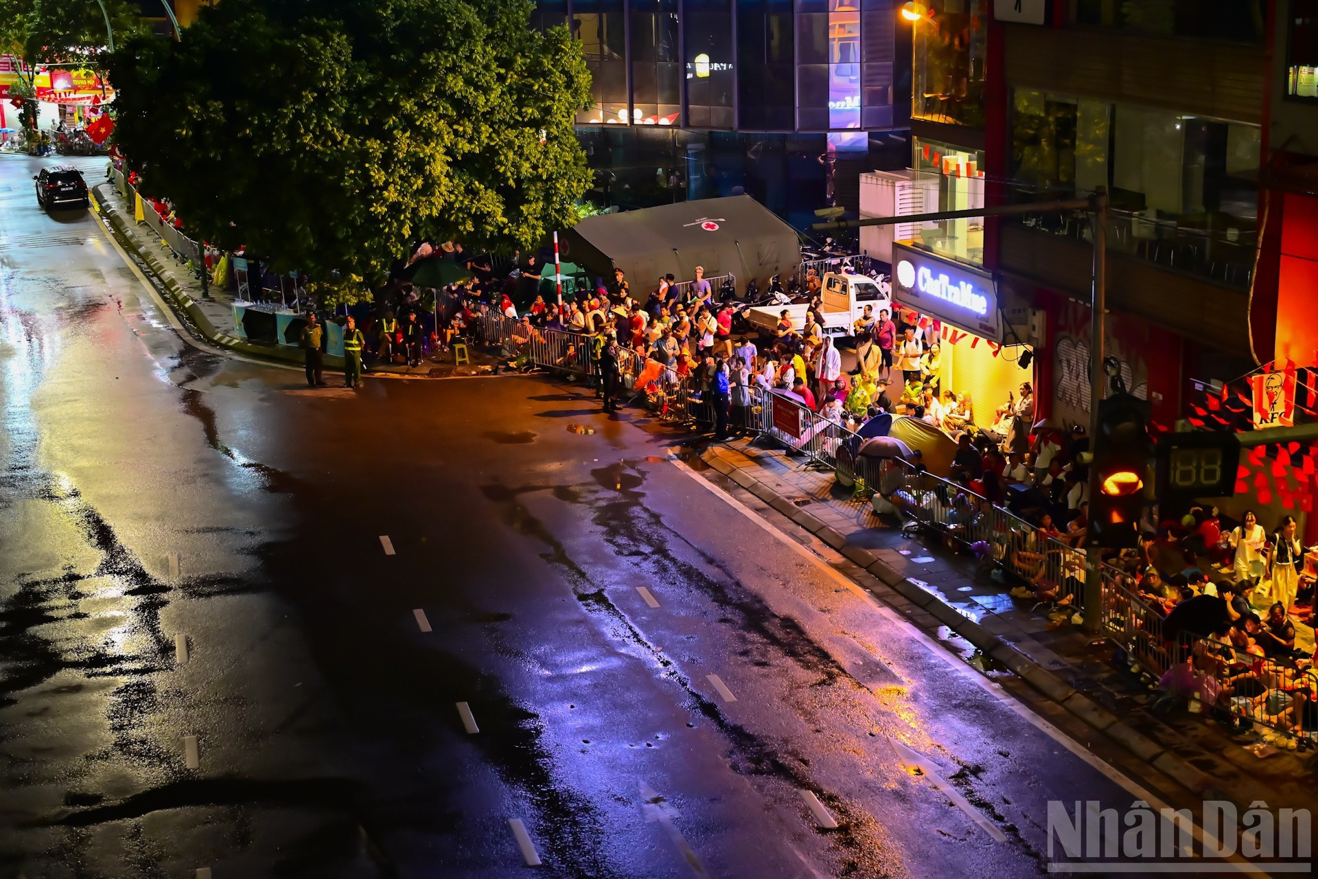 A primera hora de la mañana, la gente se reúne con gran ansiedad en las aceras de las calles por donde pasará el desfile.