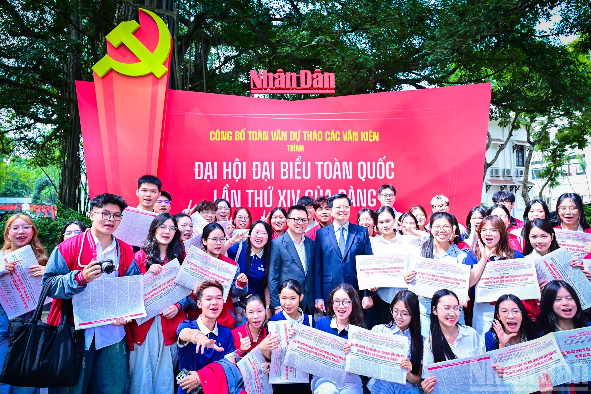 Dirigentes participantes en el conversatorio recorren la exposición en la sede de Nhan Dan y se toman fotos con lectores jóvenes.