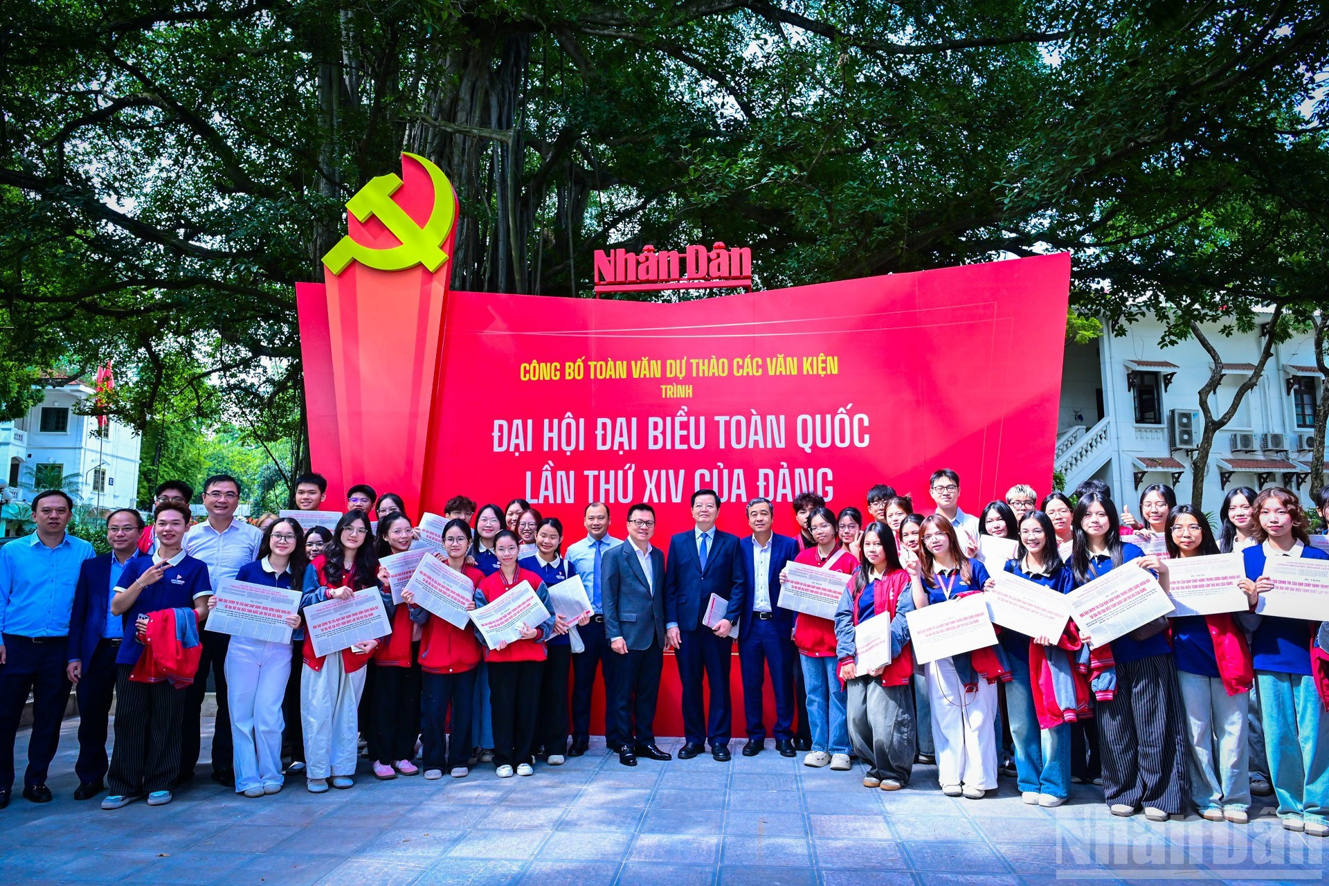 Dirigentes participantes en el conversatorio recorren la exposición en la sede de Nhan Dan y se toman fotos con lectores jóvenes.