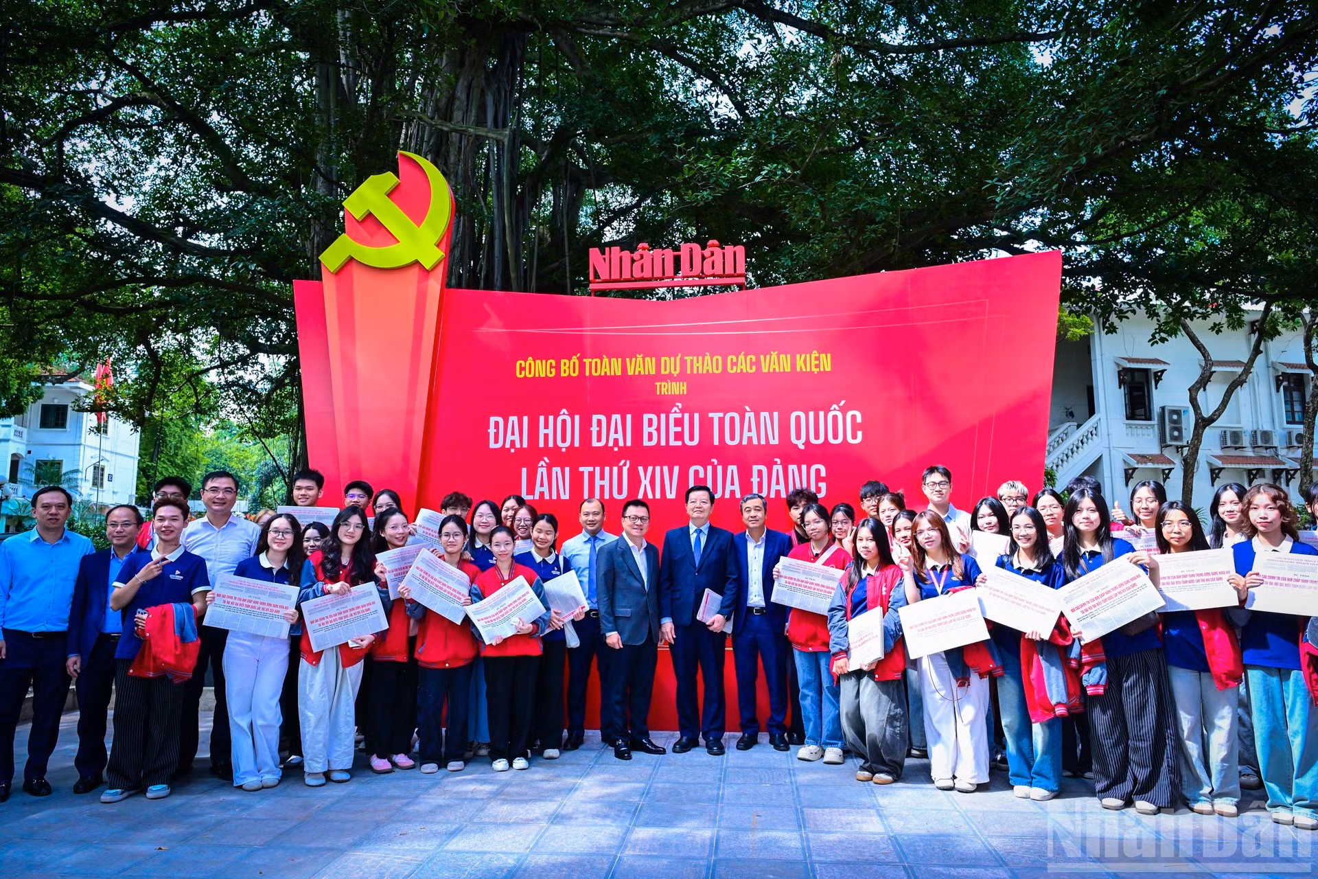 Dirigentes participantes en el conversatorio recorren la exposición en la sede de Nhan Dan y se toman fotos con lectores jóvenes.