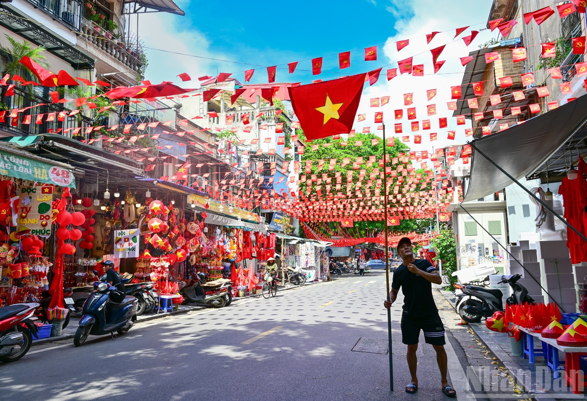 Las banderas del Partido y de la Patria flamean bajo el sol otoñal.