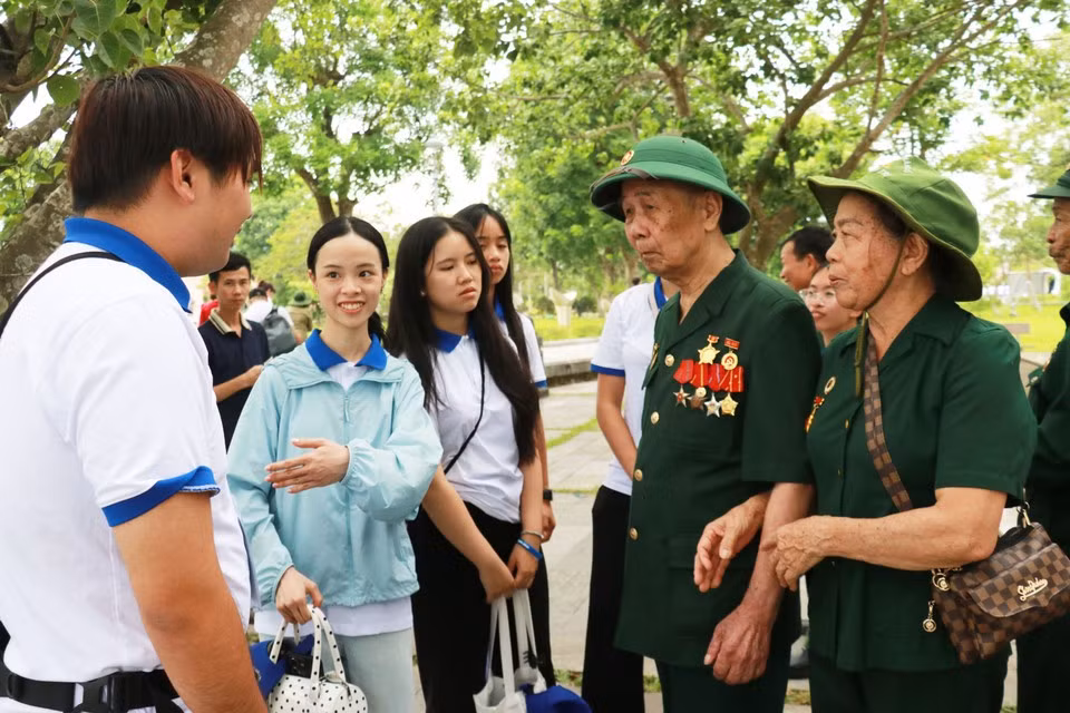 Jóvenes y estudiantes vietnamitas residentes en el extranjero conversan con veteranos de guerra.