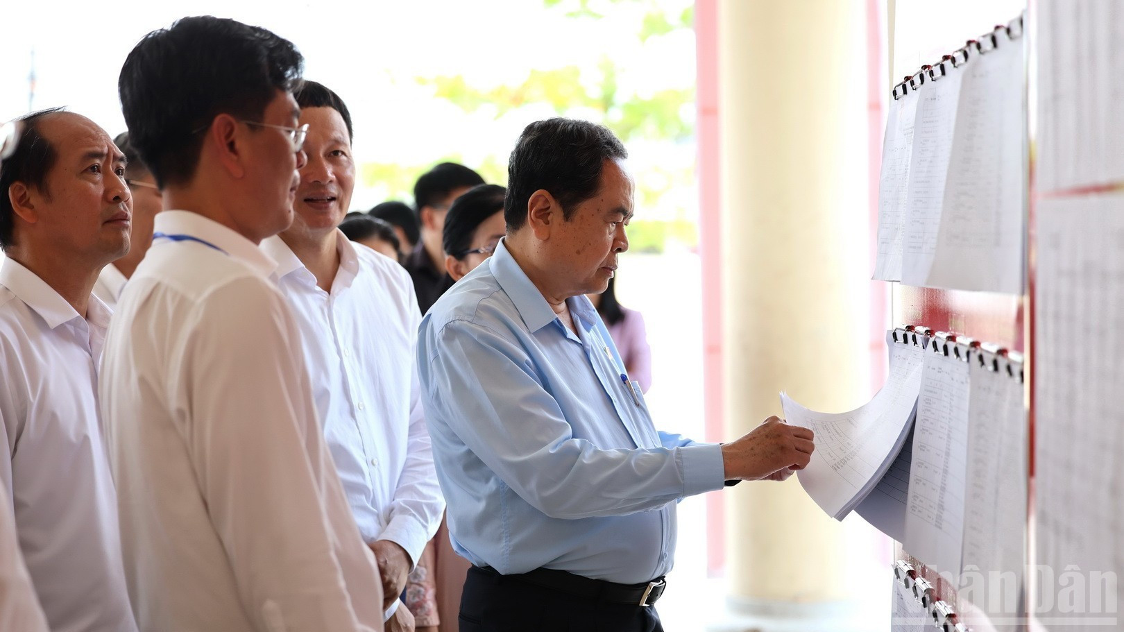 El máximo legislador nacional revisa la lista de votantes en el barrio de Tan Trieu.