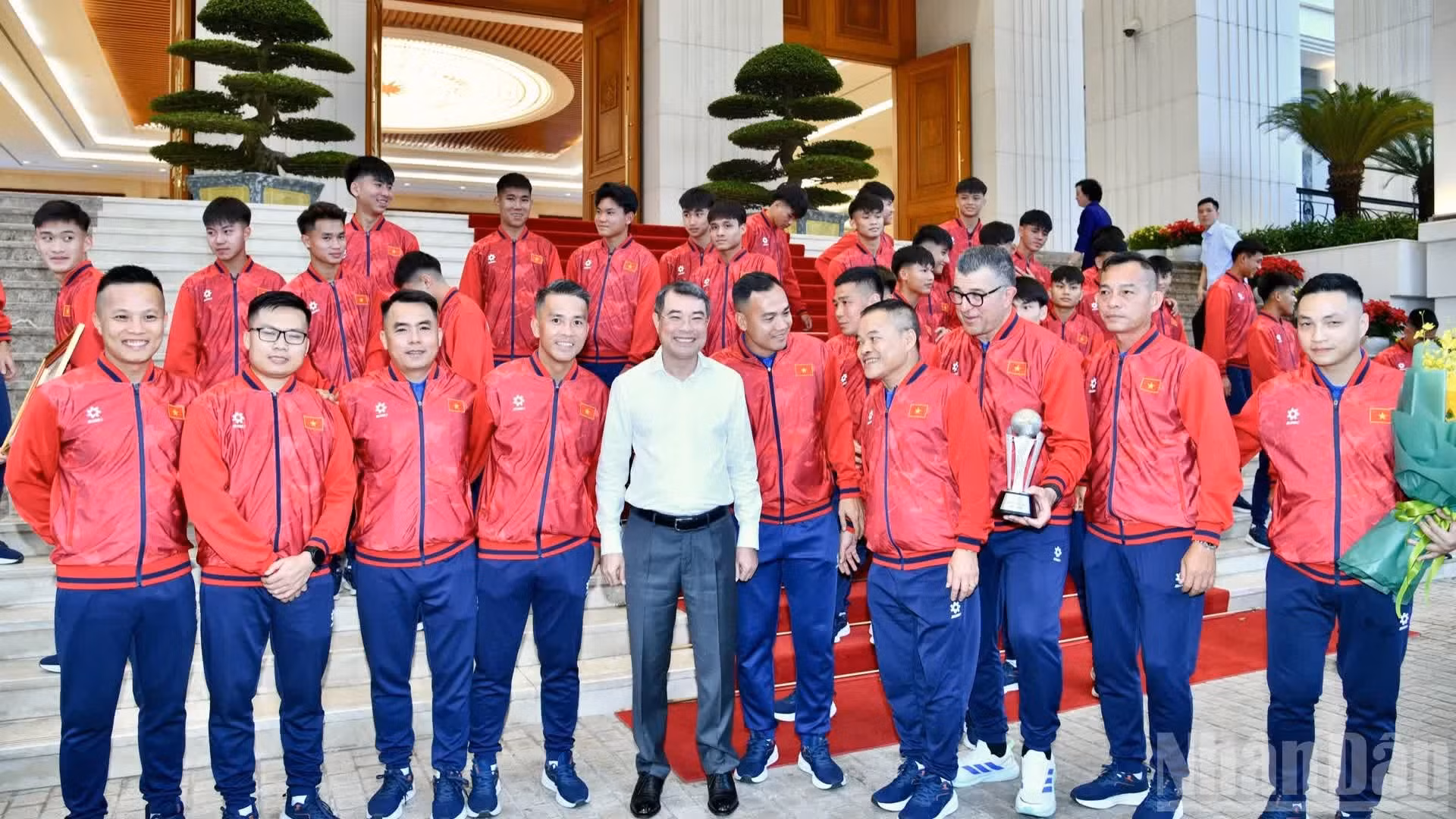 El primer ministro Le Minh Hung posa junto a miembros del cuerpo técnico y jugadores.