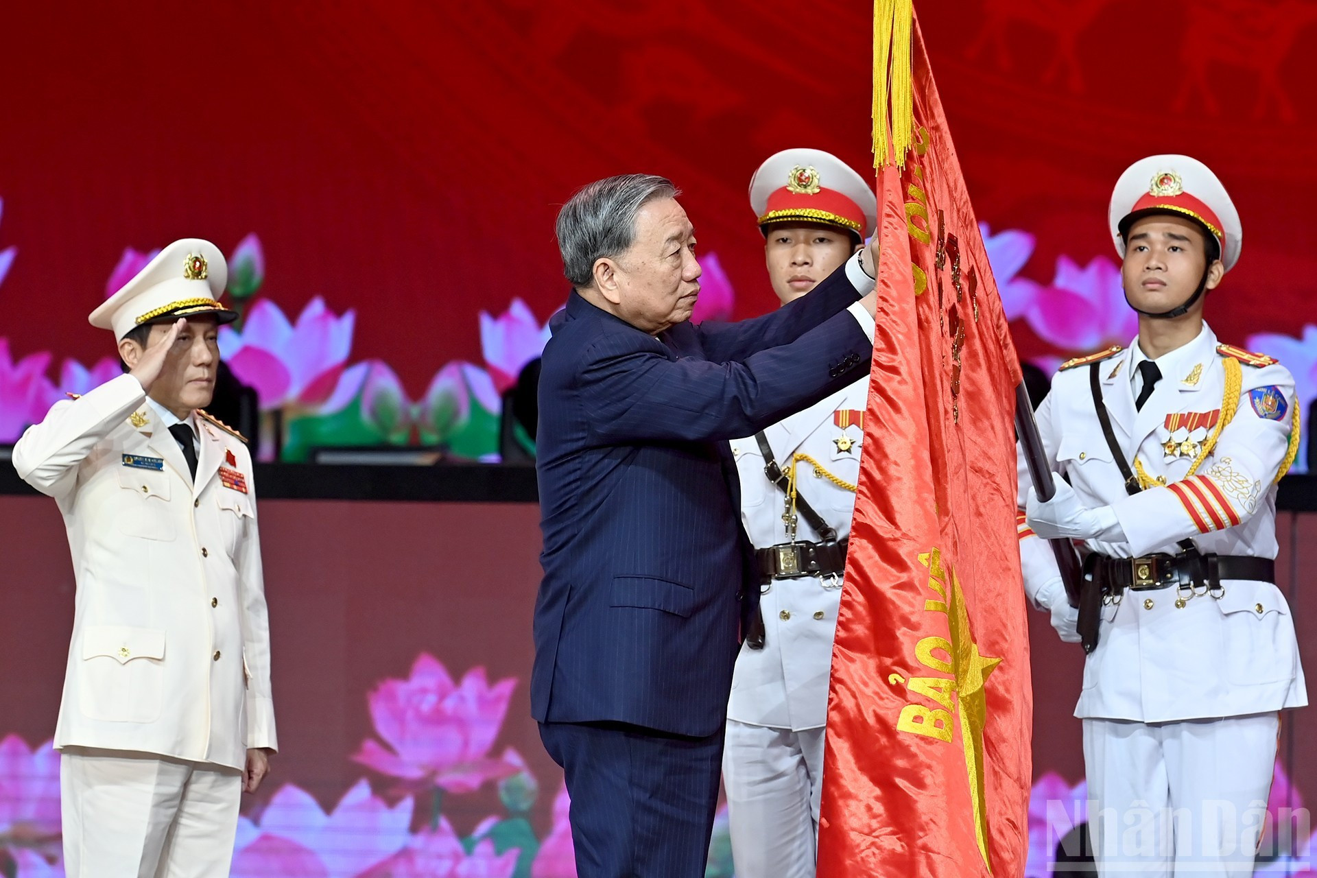 El secretario general del Partido, To Lam, pincha la Orden de la Estrella Dorada en la bandera tradicional de la fuerza de Seguridad Pública Popular.