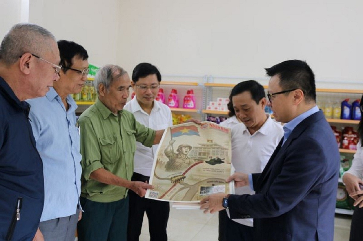 El compañero Le Quoc Minh entrega a los vecinos de Bat Trang la publicación especial de Nhan Dan en ocasión del 50º aniversario del Día de la Liberación del Sur y la Reunificación nacional. image-1-9119.jpg