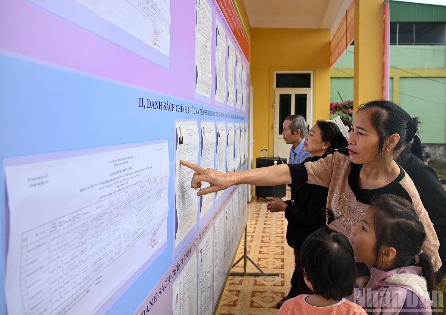 Aldeanos de Phuc Long leen la lista de candidatos y su biografía resumida.