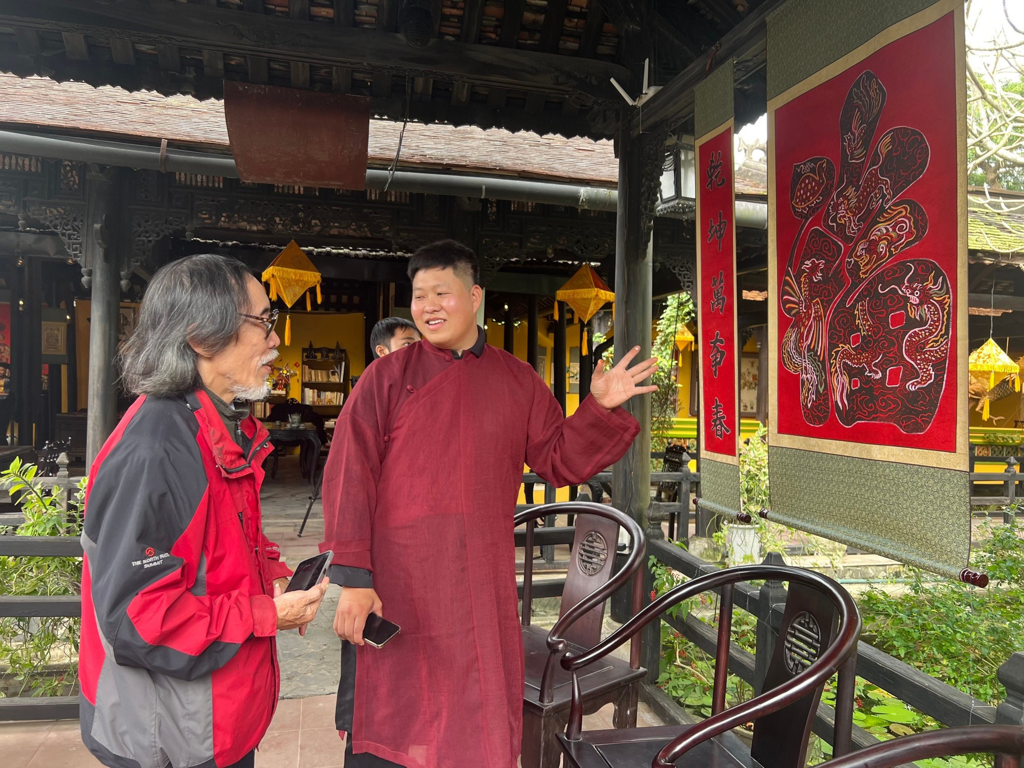 El artesano Nguyen Cong Dat conversa con Nguyen Phuoc Vinh Khanh, experto en cultura y restauración de reliquias.