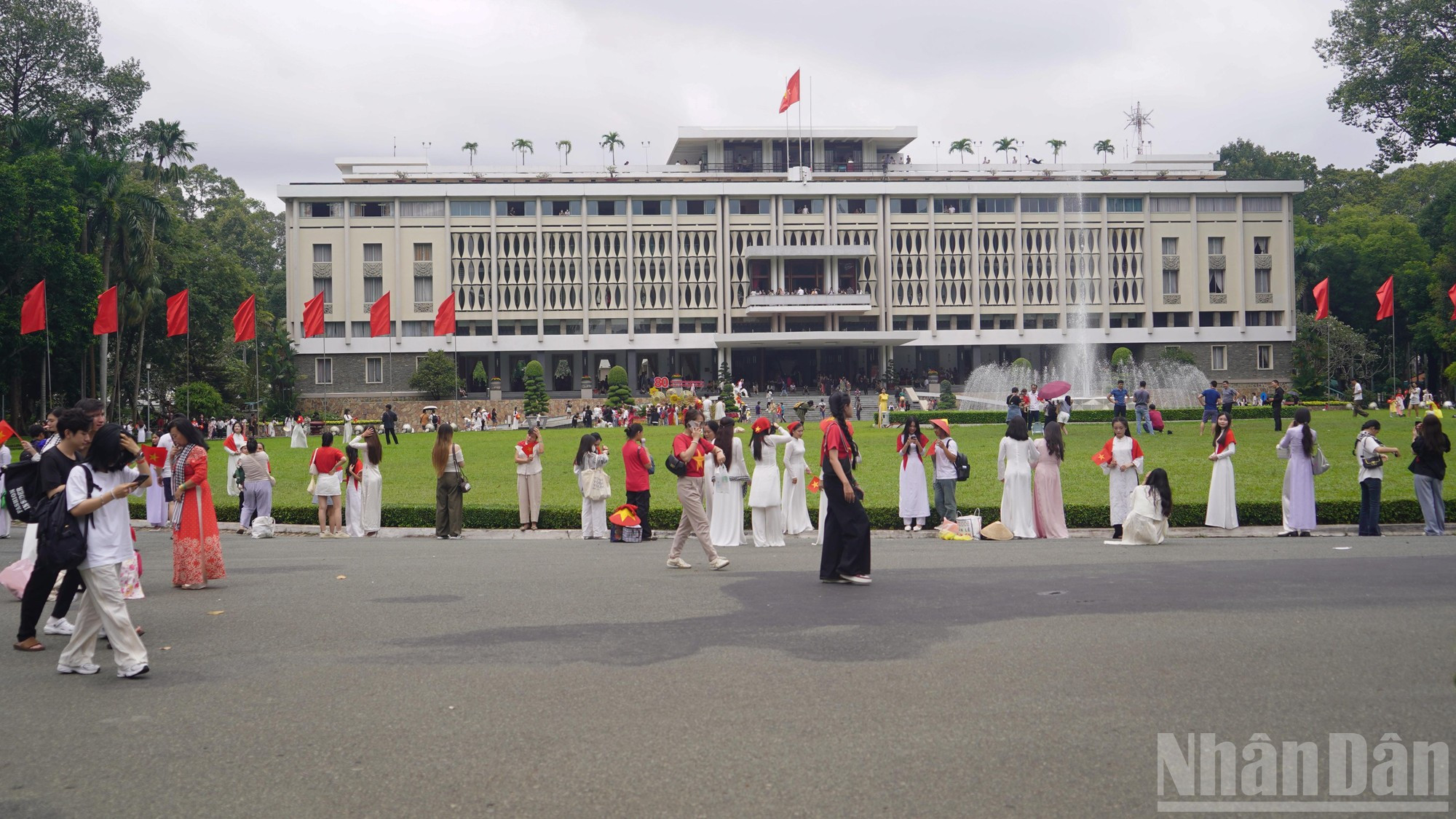 Los ciudadanos, ataviados con el ao dai (túnica tradicional de Vietnam), se toman fotos frente al Palacio de la Reunificación, también conocido como Palacio de la Independencia.