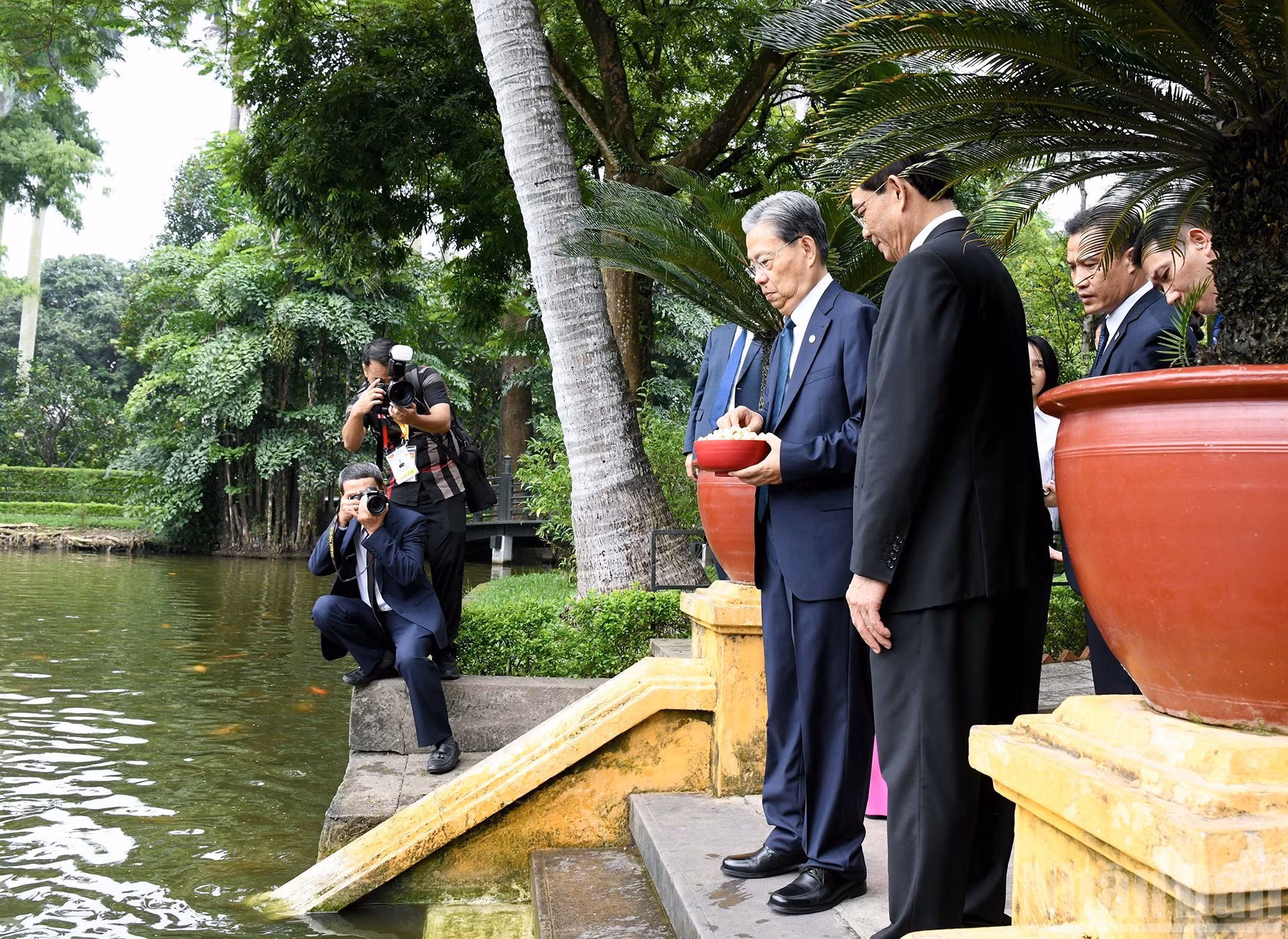 El dirigente chino da de comer a peces en el estanque del tío Ho.