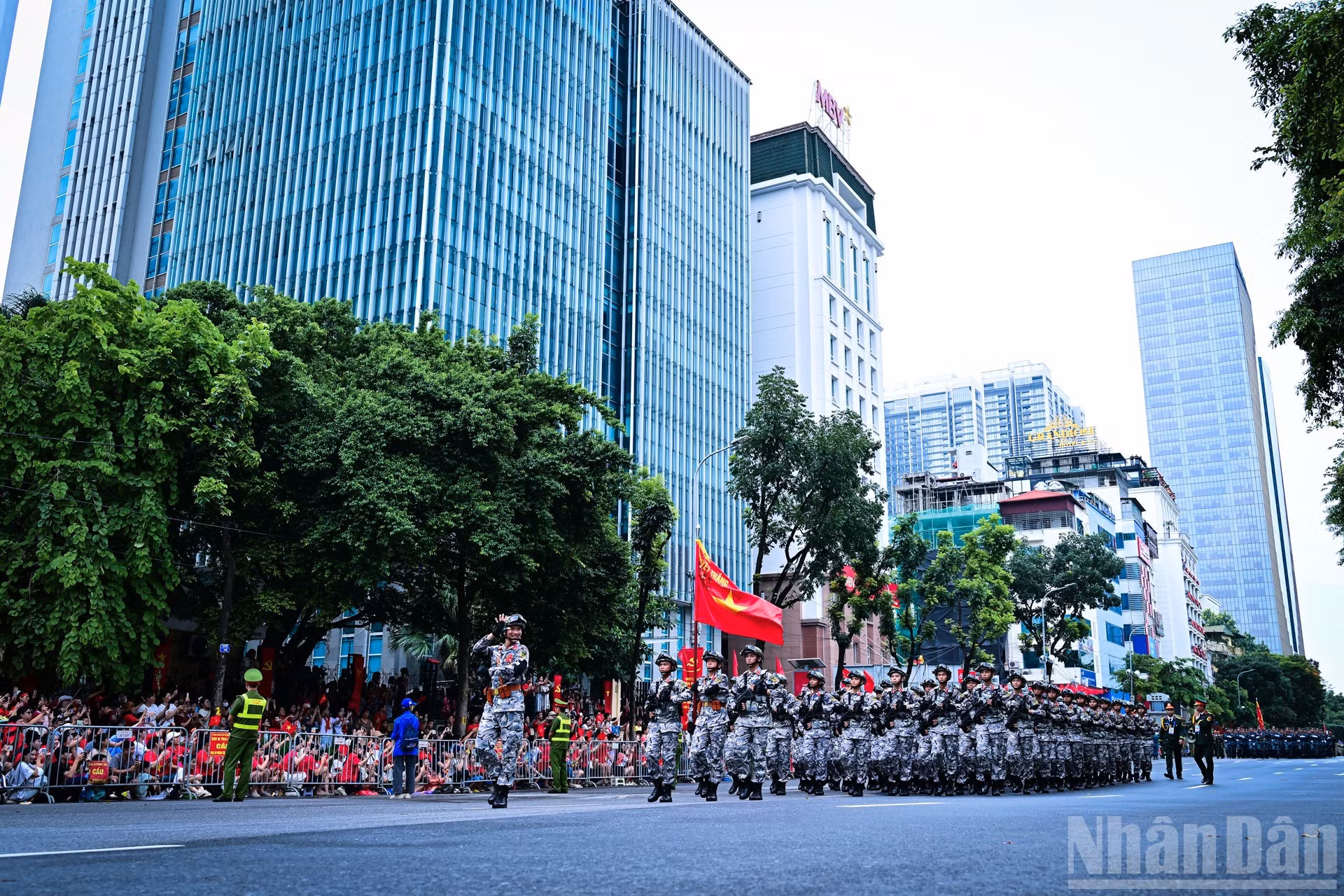 Miembros de las fuerzas especiales del Ejército devuelven el saludo de espectadores a orillas de la calle de Van Cao.