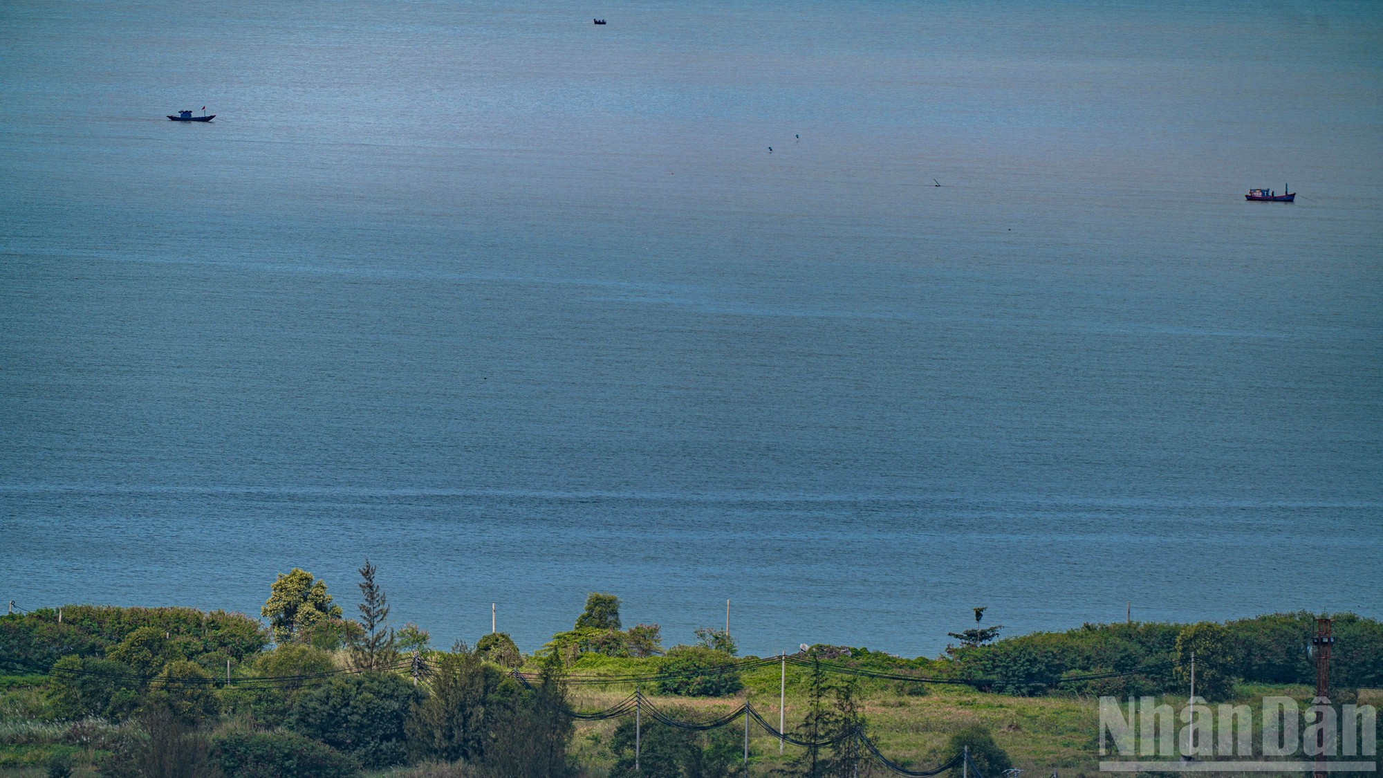 Un rayo de luz solar perfora las nubes y baña de dorado un rincón de la zona urbana costera de Da Phuoc.