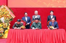 El secretario general del Partido Comunista, To Lam, el presidente, Luong Cuong, y el primer ministro, Pham Minh Chinh, presencian la firma de las nuevas normas de coordinación entre los Ministerios de Seguridad Pública, de Defensa y de Relaciones Exteriores el 6 de diciembre. (Foto: VNA)