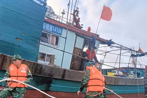Oficiales y soldados de la Guardia Fronteriza de Hai Phong ayudan a un pesquero chino a asegurar sus amarras mientras esperan condiciones climáticas favorables para ser remolcado al puerto. (Foto: VNA)