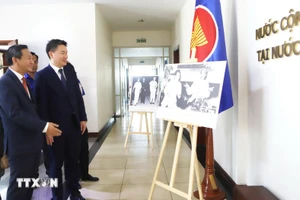 El secretario del Comité Central de la Unión de Jóvenes Revolucionarios del Pueblo de Laos, Thongly Sisoulith, visita la exposición fotográfica instalada en el evento sobre las relaciones especiales entre Vietnam y Laos. (Foto: VNA)