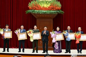 El integrante del Buró Político y miembro permanente del Secretariado del Comité Central del Partido Comunista de Vietnam, Tran Cam Tu, entrega la Orden del Trabajo de Primera Clase a las agencias con aportes excepcionales a la labor de asesoría, organización y servicio durante el XIV Congreso Nacional del Partido. 