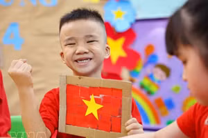 Niños vietnamitas entusiastas con taller de creación de la bandera nacional
