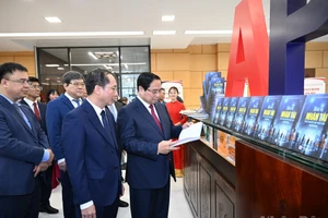 El primer ministro Pham Minh Chinh y delegados visitan el área expositiva sobre los libros y las actividades de la academia.