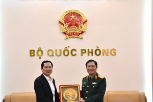 El jefe del Estado Mayor General del Ejército Popular de Vietnam y viceministro de Defensa, general Nguyen Tan Cuong (derecha), entrega un obsequio al coronel general Saichay Kommasith, viceministro de Defensa y jefe del Estado Mayor General del Ejército Popular de Laos. (Foto: qdnd.vn)