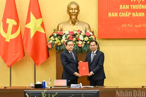El secretario del Comité del Partido Comunista de Vietnam en la Asamblea Nacional y presidente de esta, Tran Thanh Man (izquierda), entrega la decisión del Buró Político del Comité Central del Partido a Le Quang Manh.
