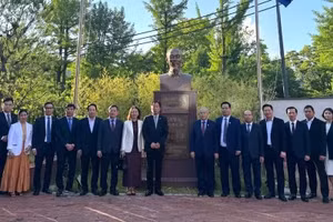 Personal de la embajada y la delegación de Hai Phong posan junto a la estatua del Presidente Ho Chi Minh en la sede de la misión diplomática vietnamita.