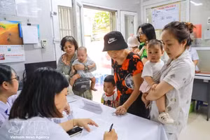 Las familias llevan a sus hijos a recibir vitamina A en la clínica del barrio de Bach Mai, en Hanói. (Foto: VNA)