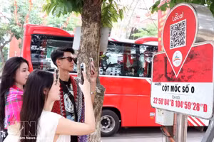 Los visitantes escanean un código QR en el marcador del kilómetro 0 de la provincia de Ha Giang para acceder a información turística. (Foto: VNA)