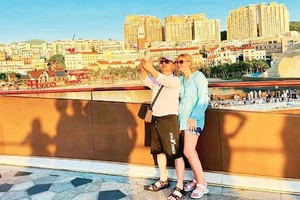 Turistas internacionales se registran en el Puente del Beso, Phu Quoc, provincia de An Giang. (Foto: Nhan Dan)