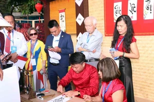 Vietnamitas en el extranjero hacen fila para pedir caligrafía. (Fuente: VNA)
